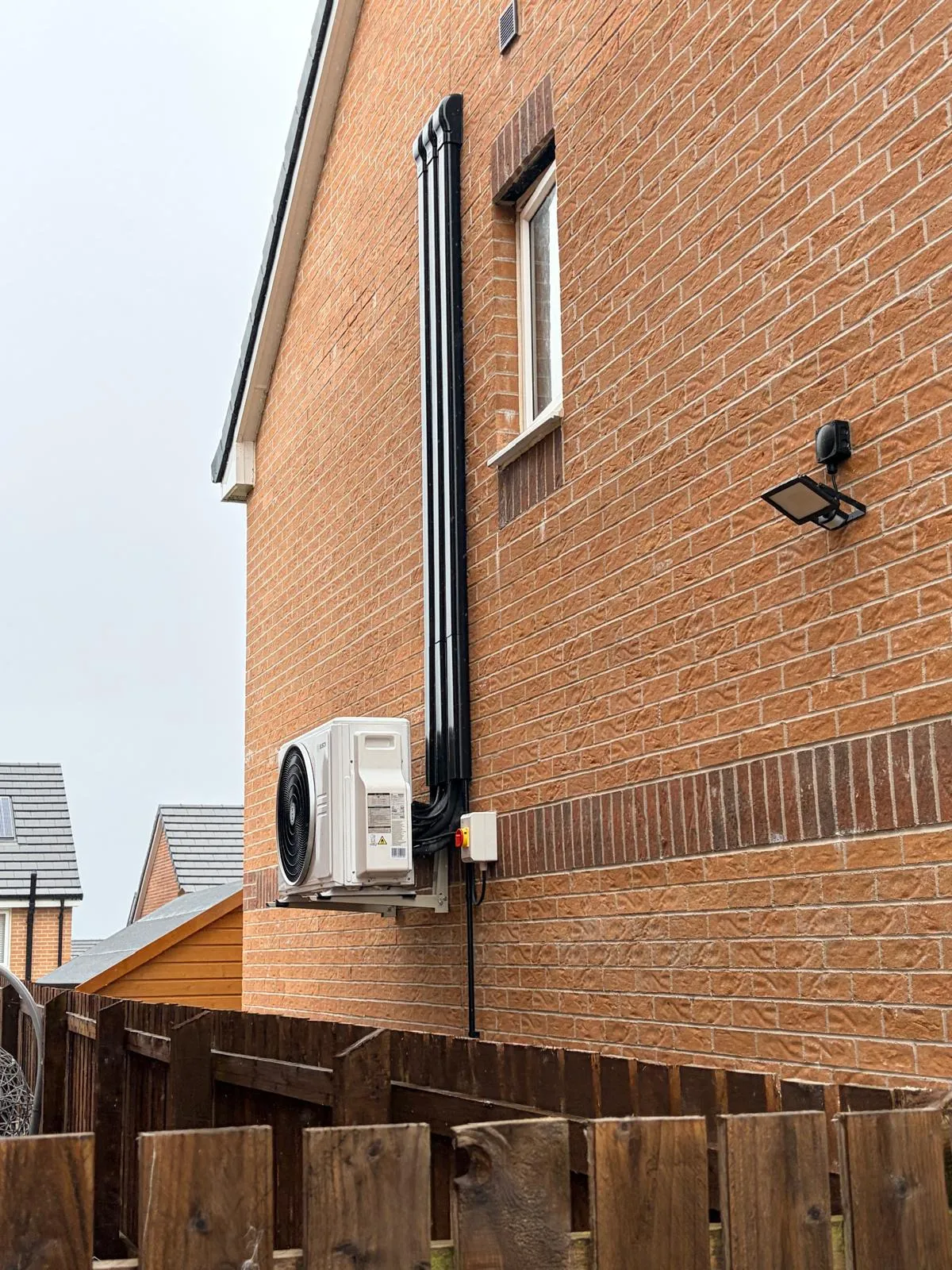 Air conditioning outdoor unit mounted on a house wall