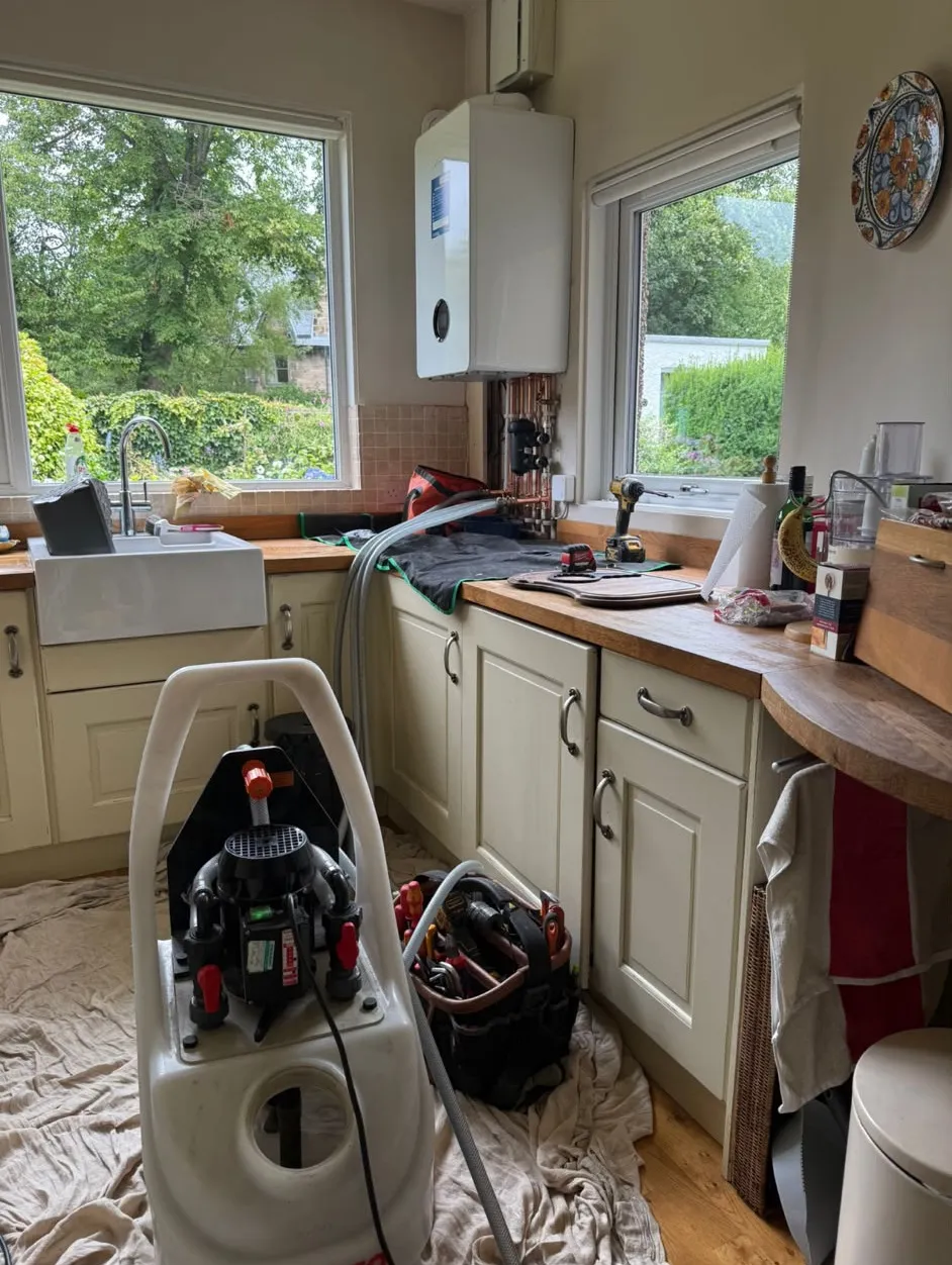 Power flushing machine connected to a central heating system in a kitchen