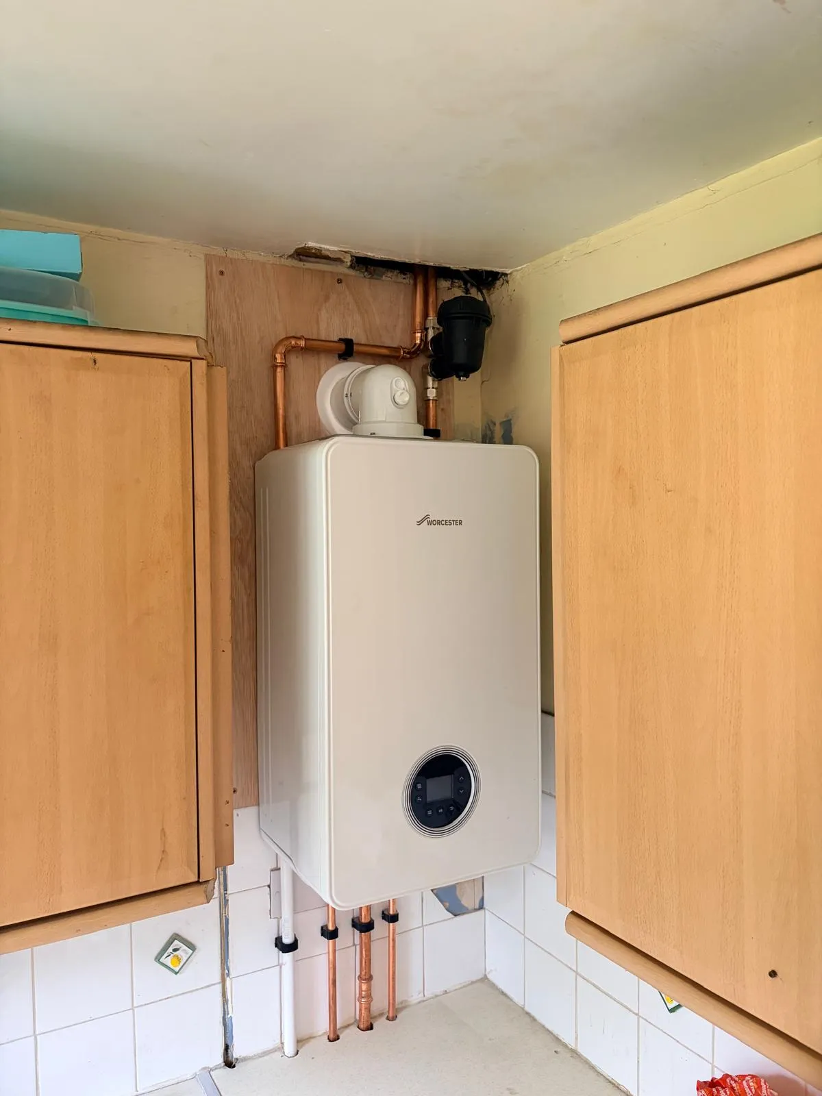 Worcester boiler installed between kitchen cupboards