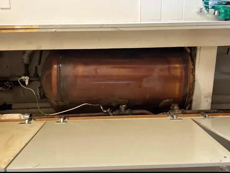 Old copper hot water cylinder unit inside storage cupboard before boiler upgrade | Buchanan Gas and Heating