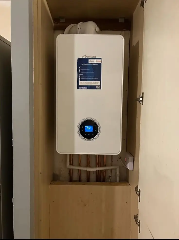 Worcester boiler neatly installed in a custom cupboard with exposed copper pipework by Buchanan Gas and Heating