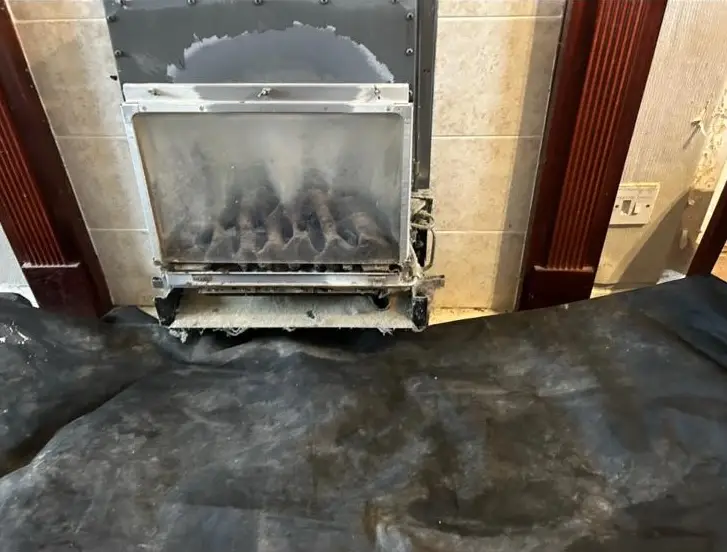 Old gas fire unit prepared for removal during heating system upgrade by Buchanan Gas and Heating